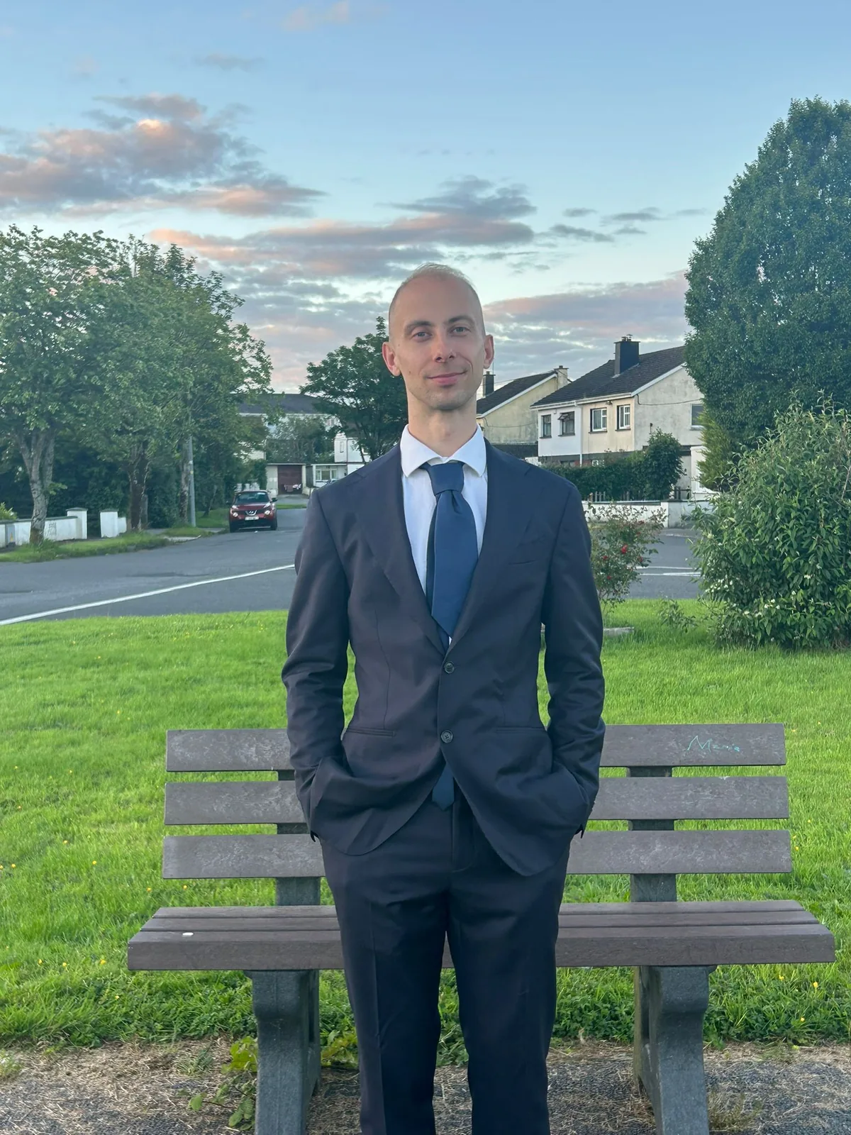 Przemyslaw Seweryniak, who builds the websites, standing by a bench in a residential Athlone estate at golden hour